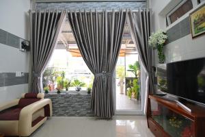 a living room with a large window with curtains at Villa SEVENBAY in Da Lat