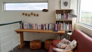 a book shelf filled with books next to a couch at JEJU Doldam B&B in Seogwipo