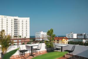 a balcony with tables and chairs and buildings at Casa Rosa Apartment in Da Nang