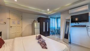 een slaapkamer met een bed en een tv aan de muur bij Lemon Loft Boutique Room in Hua Hin