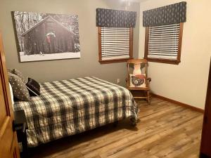 a bedroom with a bed and two windows at Myers Chalet in Ellicottville