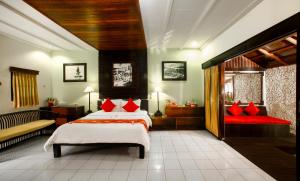 a bedroom with two beds with red pillows at Bali Taman Lovina Resort & Spa Suites in Lovina