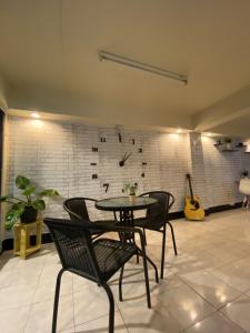 a room with a table and chairs and a guitar at FrenTé Chiang Mai in Chiang Mai