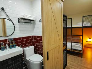 a bathroom with a toilet and a sink and a bunk bed at 濱境行旅 Begin Inn in Xiaoliuqiu