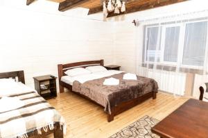 sypialnia z łóżkiem i stołem w obiekcie Wood House w mieście Pilipets