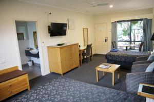 a living room with a couch and a table at Motel On A'Beckett in Inverloch