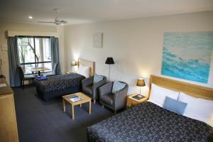 una camera d'albergo con un letto e un divano di Motel On A'Beckett a Inverloch Altre 25 foto