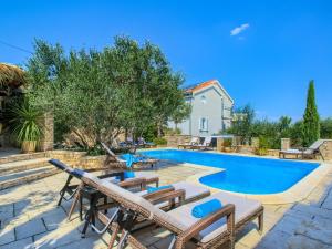 una piscina con sedie e una casa di Villa on Murter with Pool and Sea View a Murter