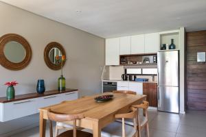 a kitchen with a wooden table and a refrigerator at Zimbali Suite 214 in Ballito