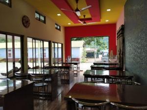 ein Restaurant mit Tischen, Stühlen und roten Wänden in der Unterkunft Bagori Resort-Best Holiday Resort in Kaziranga in Sakmuthi + 57 Fotos