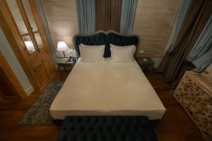 uma grande cama branca num quarto com duas almofadas em Trésor Art Boutique Hotel em Korçë