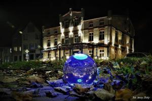 un frasco de cristal azul en el suelo frente a un edificio en Willa Joker, en Nowy Dwór Gdański