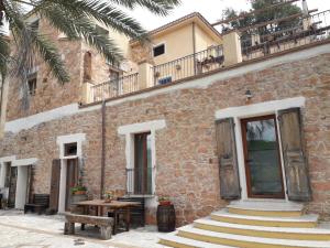 a brick building with stairs and a wooden table at Sa Perda Arrubia in Cardedu