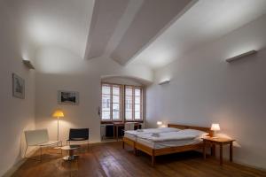 een slaapkamer met een bed en een tafel en stoelen bij Hotel a hostel Zámecký pivovar Litomyšl in Litomyšl