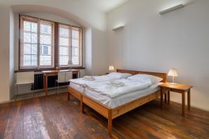 a bedroom with a large bed and two windows at Hotel a hostel Zámecký pivovar Litomyšl in Litomyšl