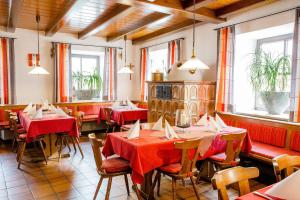 a restaurant with red tables and chairs and windows at Gasthof Krone in Bissingen