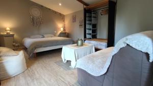 a bedroom with two beds and a table with a mirror at Domaine de l'Hôtel au Franc in Fleury