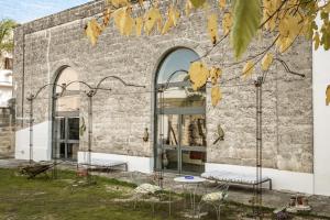 a brick building with two windows and two chairs at Stabilimento Wine & Design Apartment in Campi Salentina