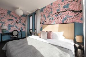 1 dormitorio con 1 cama grande y pared de flores en City Solei Boutique Hotel, en Poznan