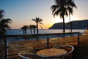 a table and chairs on a balcony with a view of the ocean at H Boutique la Caleta bay in La Herradura