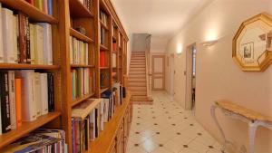 un pasillo con estanterías llenas de libros en Magnifique Maison de 230 m2 face à la tour Luma vacances-arles camargue, en Arles