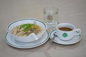 un bol de soupe et une tasse de café sur une table dans l'établissement อุทยานบ้านเชียงเครือ, à Ban Nong Bua Sang