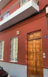 a red house with a wooden door and windows at Dream Flat in Santa Cruz de Tenerife