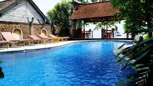 a large swimming pool with chairs and a gazebo at Diver's Cafe Amed in Amed