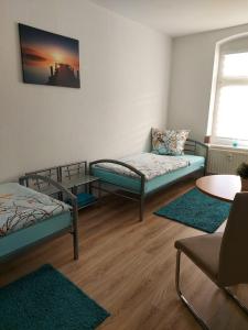 a room with two beds and a couch and a table at Apartments Irena Burkert in Chemnitz