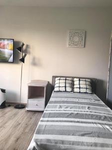 a bedroom with a bed and a night stand with a lamp at Apartament Leśna Jarosławiec in Jarosławiec