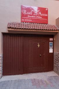 una porta rossa del garage con un cartello sopra di Riad Asma a Taroudant