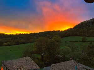 una puesta de sol sobre un campo con árboles y una casa en Il Sogno nel Vento en Tufo Basso