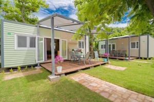 a green modular home with a deck and a patio at Armenistis Camping & Bungalows in Sarti