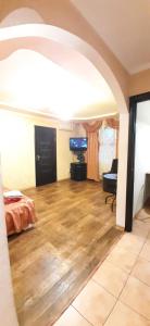 a living room with a bed and a wooden floor at 2 кімн. кв. "Романтік" in Cherkasy