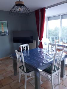 ein Esszimmer mit einem blauen Tisch und Stühlen in der Unterkunft Location Banyuls sur Mer in Banyuls-sur-Mer