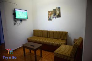 a living room with a couch and a flat screen tv at Sea Horse Hotel Dahab in Dahab
