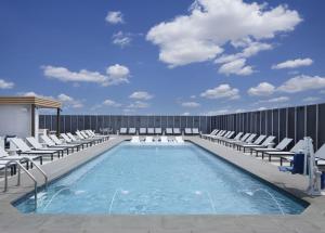 - une piscine avec des chaises longues dans un bâtiment dans l'établissement Hyatt Regency Frisco-Dallas, à Frisco