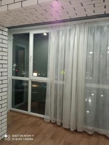 uma grande janela com cortinas brancas num quarto em 35 проспект Миру em Kryvyi Rih