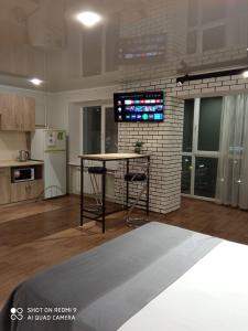 ein Wohnzimmer mit einem Tisch und einer Küche in der Unterkunft 35 проспект Миру in Krywyj Rih