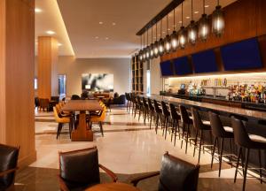 a restaurant with a bar and chairs at Hyatt Regency Frisco-Dallas in Frisco