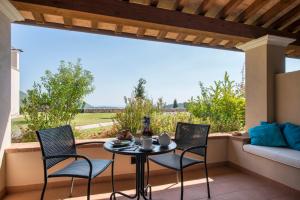 eine Terrasse mit einem Tisch und Stühlen sowie einem großen Fenster in der Unterkunft Collina Degli Ulivi B&B in Itri