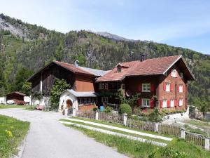 a house on a road in front of a mountain at B&B Härihof in Grüsch