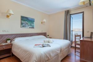 um quarto de hotel com uma cama e uma televisão em Apartamentos Carlos V na Alcúdia