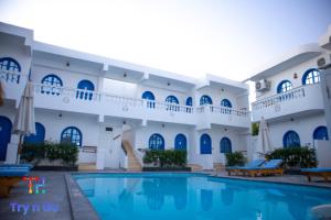 a hotel with a swimming pool in front of a building at Sea Horse Hotel Dahab in Dahab