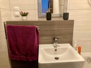 ein Bad mit einem Waschbecken und einem roten Handtuch in der Unterkunft Modern Calm Studio, Wroclaw in Breslau