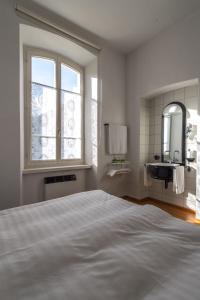 ein weißes Schlafzimmer mit einem großen Bett und einem Waschbecken in der Unterkunft Albergo Ristorante Centovalli in Ponte Brolla