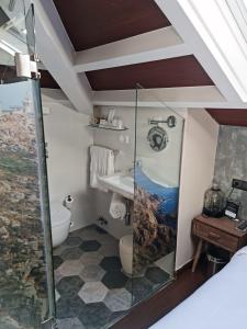 een badkamer met een douche, een toilet en een wastafel bij Hotel O Semaforo in Finisterre