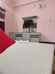 a bedroom with a large white bed and a tv at 300M FROM BEACH GLORIAS HOTEL BEACH VIEW in Mandarmoni