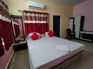 a bedroom with a large bed with red curtains at 300M FROM BEACH GLORIAS HOTEL BEACH VIEW in Mandarmoni