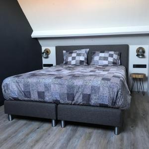 um quarto com uma cama com um cobertor xadrez em D'n Wasschappelsen Engel Windkracht 11 em Westkapelle